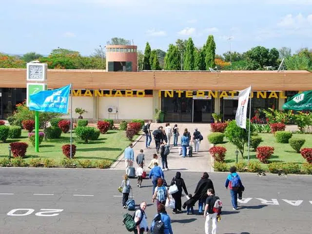Travellers with luggage outside the arrivals terminal at Kilimanjaro International Airport